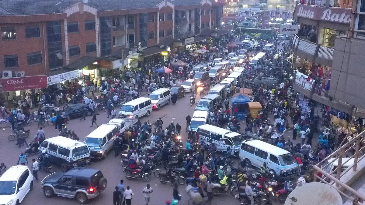 A busy downtown Kampala street full of taxis and boda-bodas